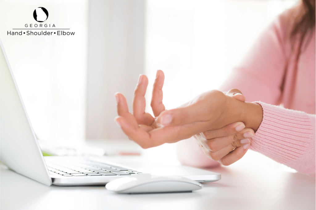 A woman with wrist pain from using a mouse while working with a computer in Georgia.